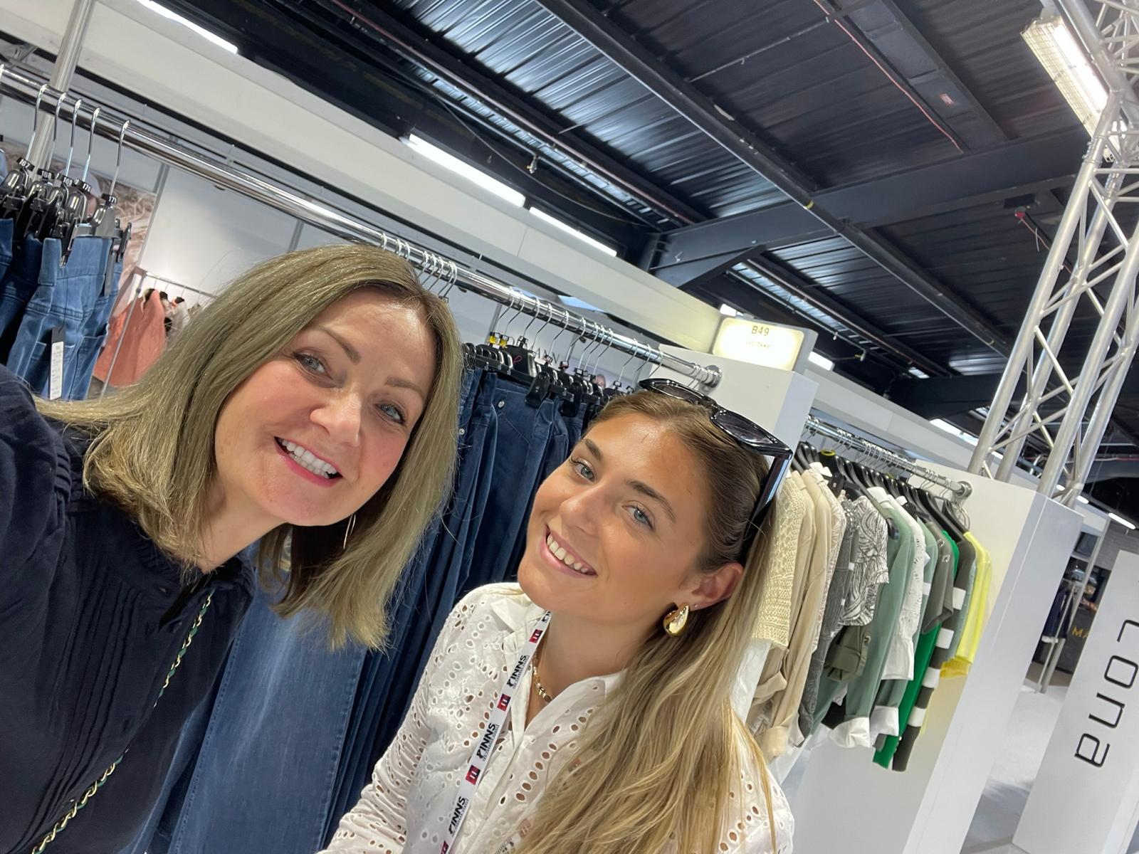 Lucy and Hannah choosing new clothing collections at a fashion trade show